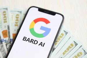 Kiew, Ukraine - - März 17, 2024 Google Barde Logo auf iPhone Anzeige Bildschirm mit viele hundert Dollar Rechnungen foto