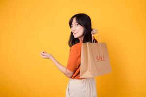 Schritt in ein Welt von lächelt, Einkaufen, und Stil. glücklich asiatisch jung Frau hält Taschen, symbolisieren das Freude von Einkauf modisch Artikel beim ermäßigt Preise. foto