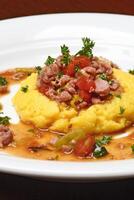 Mais Polenta mit Würstchen und Tomaten foto