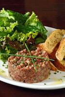 Steak Tartar mit Blatt Salat und rustikal Kartoffeln foto