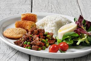 gehackt Fleisch mit Reis, paniert Banane, Reis, Käse Gebäck und Salat mit Herzen von Palme foto