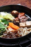 Schritt für Schritt leiten zu Sukiyaki, ein klassisch japanisch Gericht mit Gemüse, Butter, Soße, Fleisch und Tofu Käse foto