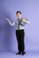 Porträt von asiatisch männlich Geschäftsmann Stehen und posieren auf lila Hintergrund foto