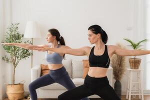 ein jung passen Frau Praktiken Methoden Ausübungen Yoga durch tun Asanas im ein hell Yoga Studio. Yoga Praktiker mit Studenten im Yoga Klasse. foto