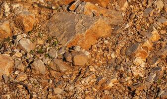 rot Felsen von anders Formen und Größen auf das Boden. Orange Textur. Hintergrund. zum Text. zum Banner. horizontal foto