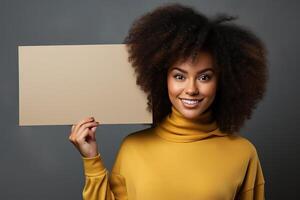 ein Mädchen mit afro Locken hält ein leer Papier mit ein Attrappe, Lehrmodell, Simulation im ihr Hände. Person mit Weiß Banner isoliert auf Studio Hintergrund. foto