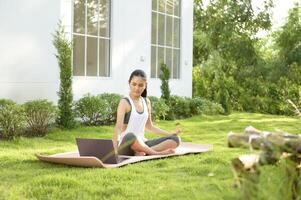 jung Frau im Sportbekleidung tun Meditation trainieren und Yoga draussen, gesund Lebensstil, mental Gesundheit Konzept. foto