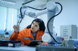 weiblich Robotik Ingenieur Arbeiten mit Programmierung und manipulieren Roboter Hand, industriell Robotik Design, hoch Technik Einrichtung, modern Maschine Lernen. Masse Produktion Automatik. foto