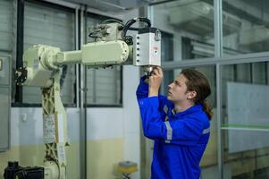 männlich Robotik Ingenieur Arbeiten mit Programmierung und manipulieren Roboter Hand, industriell Robotik Design, hoch Technik Einrichtung, modern Maschine Lernen. Masse Produktion Automatik. foto