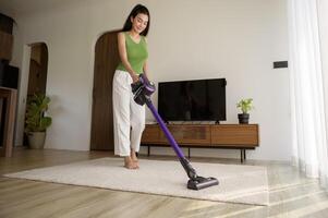 jung glücklich Frau mit ein Vakuum Reiniger das Fußboden im Leben Zimmer foto