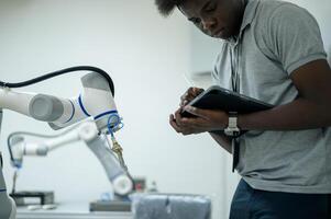 Auszubildender Robotik Ingenieur Lernen mit Programmierung und manipulieren Roboter Hand, industriell Robotik Design, hoch Technik Einrichtung, modern Maschine Lernen. Masse Produktion Automatik. foto