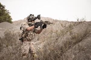 Soldaten im tarnen Uniformen Zielen mit ihr Gewehre bereit zu Feuer während Militär- Betrieb im das Wüste Soldaten Ausbildung im ein Militär- Betrieb foto