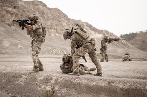 Soldaten im tarnen Uniformen Zielen mit ihr Gewehre bereit zu Feuer während Militär- Betrieb im das Wüste Soldaten Ausbildung im ein Militär- Betrieb foto