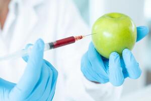 Wissenschaftler prüfen chemisch Essen Rückstände im Labor. Steuerung Experten prüfen Qualität von Frucht, Wissenschaftler injizieren Chemikalien in Äpfel zum Experimente, Gefahren, verboten Substanz, verunreinigen foto