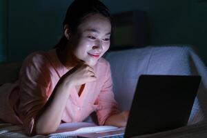 Foto von jung asiatisch Frau mit Laptop im das dunkel beim Mitternacht