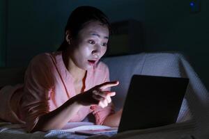 Foto von jung asiatisch Frau mit Laptop im das dunkel beim Mitternacht