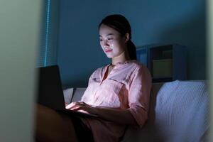 Foto von jung asiatisch Frau mit Laptop im das dunkel beim Mitternacht