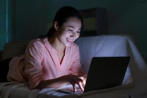 Foto von jung asiatisch Frau mit Laptop im das dunkel beim Mitternacht