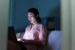 Foto von jung asiatisch Frau mit Laptop im das dunkel beim Mitternacht