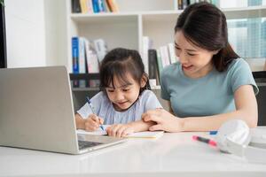 Foto von jung asiatisch Mutter und Tochter studieren beim Zuhause