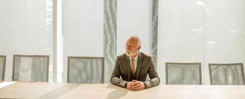 Senior Geschäft Mann Sitzung im das Sitzungssaal beim das Büro foto