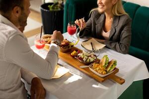 jung Paar haben Mittagessen und Trinken frisch gedrückt Saft im das Restaurant foto