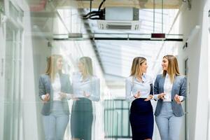 zwei jung Geschäft Frauen Gehen und diskutieren im das Büro Flur foto