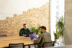 Zusammenarbeit im Bewegung, Profis Arbeiten zusammen im ein modern gemauert Büro foto