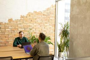 Zusammenarbeit im Bewegung, Profis Arbeiten zusammen im ein modern gemauert Büro foto