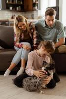 Familie Verbindung Zeit mit spielerisch Französisch Bulldogge Welpe im gemütlich Leben Zimmer foto