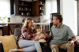 gemütlich Familie Zeit, Teilen Lachen und Popcorn auf ein beiläufig Abend foto