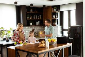 Familie chatten und vorbereiten Essen um ein geschäftig Küche Zähler gefüllt mit frisch Zutaten und Kochen Utensilien foto