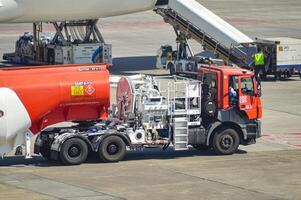 ein Treibstoff Panzer LKW vorbereiten zu füllen Luftfahrt Turbine Treibstoff auf ein Flugzeug geparkt beim Juanda International Flughafen, Surabaya, Indonesien, 29 Juli 2023 foto