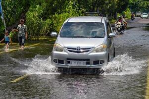 mehrere Fahrzeuge eine solche wie Lastwagen, Fahrräder und Autos wurden gefangen durch Hochwasser im gresik Regentschaft, Indonesien, 21 Februar 2024. foto