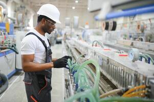 Fachmann schwer Industrie Ingenieur Arbeiter tragen Uniform, Brille und schwer Hut im ein Fabrik foto