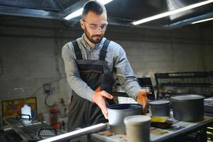 Drucken Haus Innere mit modern Versatz drucken Maschine und Operator im Arbeiten Uniform Überprüfung Qualität und steuern Prozess von drucken foto