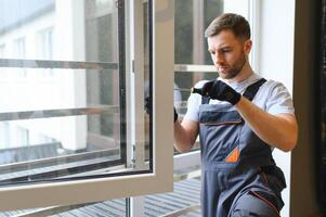 Arbeiter im Overall Installation oder einstellen Plastik Fenster im das Leben Zimmer beim Zuhause foto