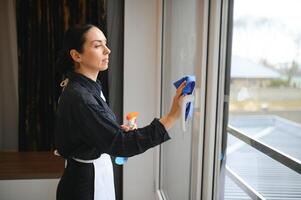 ziemlich Zimmermädchen Reinigung Fenster im Hotel Zimmer foto