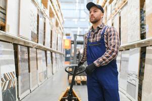 ein Arbeiter im ein Hardware- Geschäft steht im ein Warenhaus foto