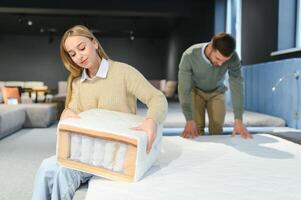 Paar Kauf Neu Bett mit orthopädisch Matratze im Möbel Geschäft foto
