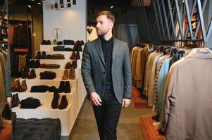 Verkauf, Einkaufen, Mode, Stil und Menschen Konzept - - elegant jung Mann im passen im Einkaufszentrum oder Kleidung Geschäft foto