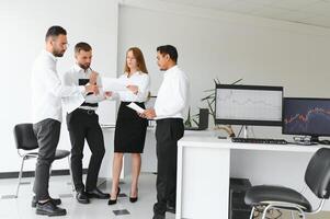 Team bei der Arbeit. Gruppe junger Geschäftsleute in eleganter Freizeitkleidung, die im Kreativbüro zusammenarbeiten foto