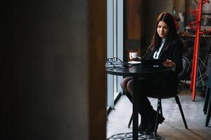 jung Geschäftsfrau mit Tablette Computer im Kaffee Geschäft. foto