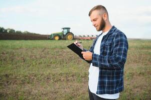 Farmer Arbeiten auf Feld im modern Landwirtschaft - - Traktor Hintergrund. foto