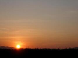 spektakulär Sonnenuntergang über, Orange Sonne steigend oben Über das Horizont foto