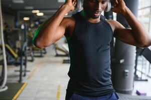 jung Afroamerikaner Mann im ein Fitnessstudio vorbereiten zu Übung foto