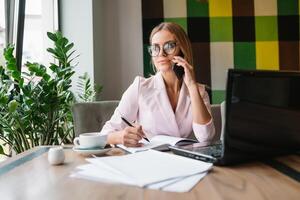 schön Geschäft Dame Trinken Kaffee und Verwendet anders Gadgets foto