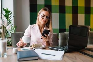 schön Geschäft Dame Trinken Kaffee und Verwendet anders Gadgets foto