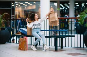 Einzelhandel, Geste und Verkauf Konzept - - lächelnd Teenager Mädchen mit viele Einkaufen Taschen beim Einkaufszentrum. foto