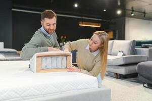 Paar Kauf Neu Bett mit orthopädisch Matratze im Möbel Geschäft foto